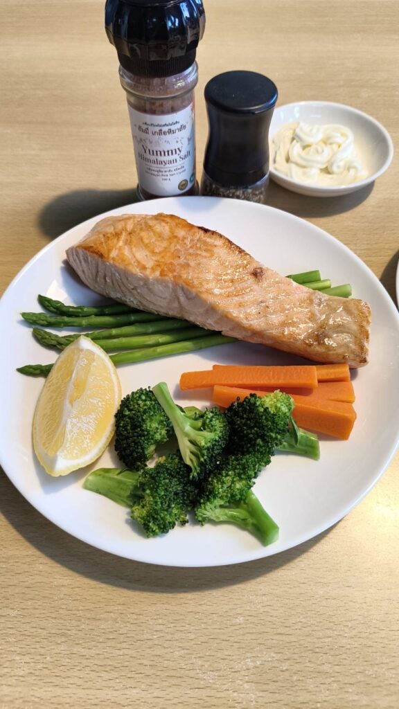 Grilled salmon seasoned simply with Himalayan pink salt, served with vegetables as an example of minimal seasoning and natural flavor-focused cooking.